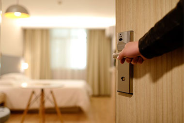 Person opening a hotel room door.